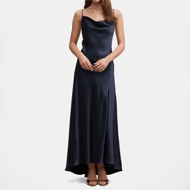Model wearing navy satin maxi slip dress with cowl neck, thin straps, and high-low hem, styled with strappy heeled sandals