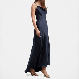 Model wearing navy satin slip maxi dress with cowl neck and thin straps, styled with metallic heeled mules