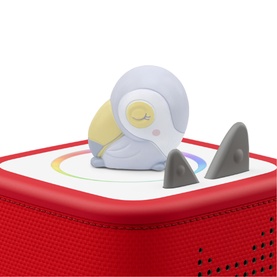 Tonies character figure of a sleepy grey bird with yellow markings, shown placed on top of a red Toniebox speaker