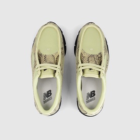 New Balance trainers in morel black, pale yellow upper with snake-print overlay panels, white laces, top-down view