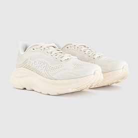 Hoka trainer in Alabaster Oat Milk, chunky white midsole, mesh and suede upper, tonal lacing, three-quarter angle view.