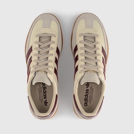 Adidas trainers in off-white with shadow red three-stripe detailing, gum sole, and matching laces, overhead view