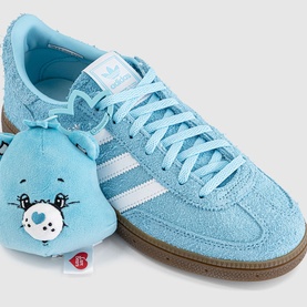 Adidas Care Bears Handball Spezial in Bliss Blue, light blue suede upper with white stripes, gum sole, styled with matching Care Bear plush toy.