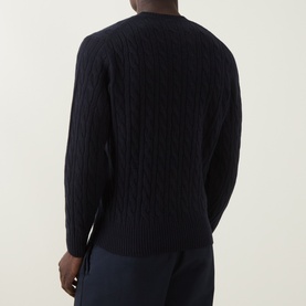 Model wearing Lacoste Navy Blue wool crew neck jumper, rear view, showing cable-knit texture, paired with navy trousers