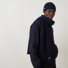Model with Lacoste Croc Logo Beanie Hat & Scarf Set in navy blue, ribbed knit construction, Croc logo detail, styled with navy jacket