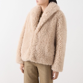 Model wearing Marella sand faux fur coat with wide lapels and cropped length, styled with khaki trousers.