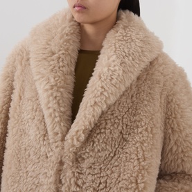 Model wearing Marella sand faux shearling coat, close-up showing oversized lapel collar and textured fluffy fabric