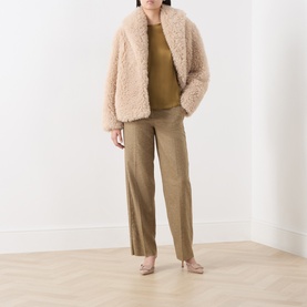 Model wearing Marella Oil Green silk-blend shirt with cream faux fur jacket, khaki wide-leg trousers and nude heels.