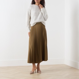 Model wearing Marella oil green pleated midi skirt, styled with a cream knit sweater and nude heels.