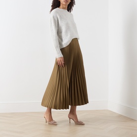 Model wearing Marella oil green pleated midi skirt, styled with a grey knit sweater and nude heels.