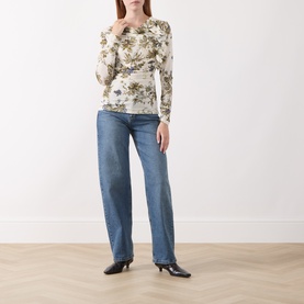 Model wearing Marella wool white floral print long-sleeve top with ruched detail, styled with blue straight-leg jeans and black kitten heels.