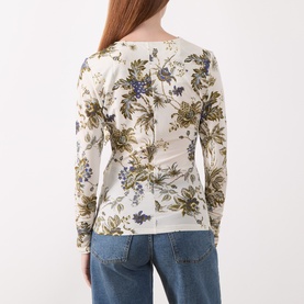 Model wearing Marella wool white floral print long-sleeve fitted top, styled with light blue jeans. Back view.