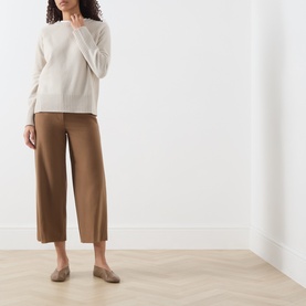 Model wearing Marella Turtledove wool knit top with wide-leg camel trousers and beige flat loafers.