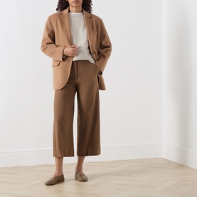 Model wearing Marella turtledove wool knit top, styled with camel blazer and wide-leg culottes, paired with taupe flat mules.