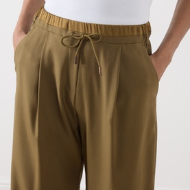 Model wearing Marella Oil Green wide-leg wool trousers with elasticated drawstring waist and side pockets, close-up detail view