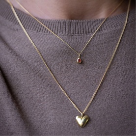 Model with Juvi July Mini Birthstone Charm Necklace in red gold, 18kt gold-plated sterling silver chain with cubic zirconia detail, styled with gold