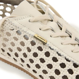 All Saints parchment white woven leather lace-up sneaker, close-up of hexagonal cut-out detail with gold branding tab.