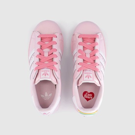 Adidas Superstar x Care Bears kids' pink leather trainers, bright pink laces, white three stripes, rainbow heel detail, top-down view