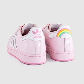 Pink adidas Superstar trainers with rainbow heel detail, silver stripe, pink sole, shown from rear angle