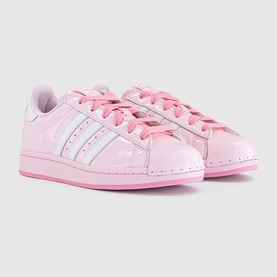 Adidas Superstar trainers in pink patent leather with three white stripe detailing and pink laces on a matching pink sole