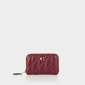Coach Dark Cherry quilted leather cardholder with gold C logo clasp and zip-around closure