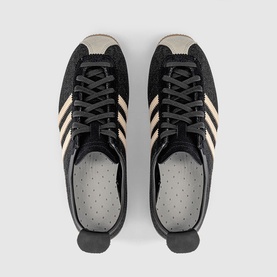 Adidas trainers in Core Black and Sand Strata, black suede upper with cream three stripes, black rubber sole, top-down view