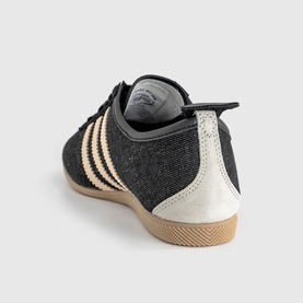 Adidas trainer in Core Black and Sand Strata, textured upper with stripe detailing, cream toe cap and gum rubber sole, rear view.