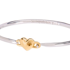 Kate Spade Heart Charm Bangle in silver and gold tone, featuring interlocking heart clasp with cubic zirconia detail and embossed branding