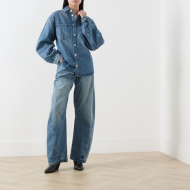 Model wearing Samsoe & Samsoe sephia blue denim shirt with matching wide-leg jeans and black leather shoes.