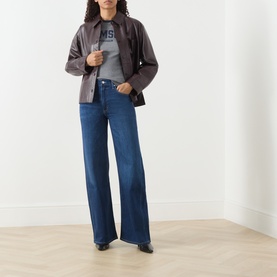Model wearing Samsoe & Samsoe mid grey mel cotton T-shirt, styled with dark brown jacket and wide-leg blue jeans.