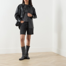 Model wearing Samsoe & Samsoe black pigment cotton T-shirt, styled with black leather jacket, tailored shorts, and black ankle boots.