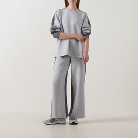 Model wearing Spanx Sweat Bottoms in grey with side stripe detail, styled with matching grey sweatshirt and grey trainers