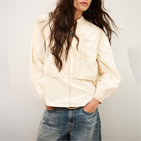 Model wearing Bash cream embroidered jacket with mandarin collar and puff sleeves, styled with blue denim jeans