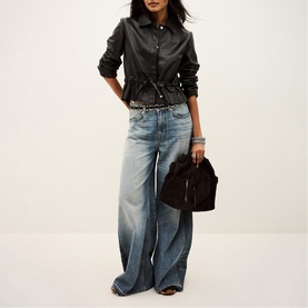 Model carrying Bash Dump bag in black, styled with leather shirt, wide-leg jeans and stacked bracelets