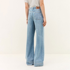 Model wearing Bash blue wide-leg jeans, rear view, high-rise fit with patch pockets, styled with a grey T-shirt
