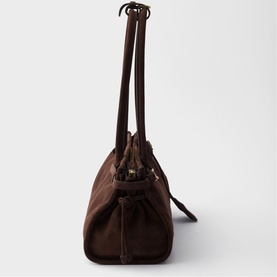 Dark brown structured tote bag with dual top handles, drawstring detail, and gold-tone hardware, shown from the side