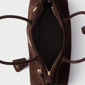 Dark brown suede tote bag, open top-down view showing quilted interior lining, gold-tone zip fastening and hardware details
