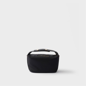 Small black structured bag with gold-tone hardware, zip closure, and short top handle, shot on white background.