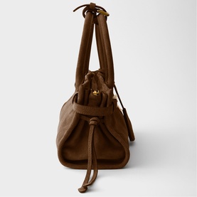 Tan brown leather drawstring bag with gold-tone hardware, dual top handles and tassel tie detail, side angle view