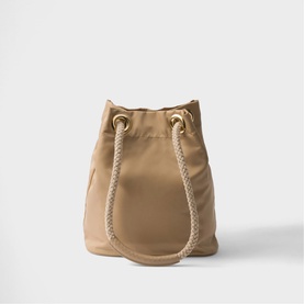 Beige nylon bucket bag with rope handles and gold-tone eyelets, drawstring closure, structured silhouette