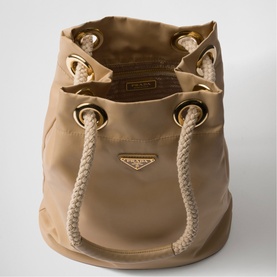 Prada beige nylon bucket bag with gold-tone eyelets, rope drawstring, and triangular logo plaque