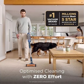 Shark PowerDetect Speed Cordless Vacuum in use on carpet in a living room, with a man and dog nearby. Text highlights #1 Vacuum Brand UK Sales.