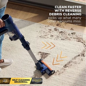 Shark PowerDetect Speed Cordless Vacuum in blue cleaning debris from carpet, showing reverse debris cleaning feature and self-cleaning brushroll.