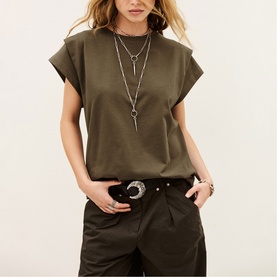 Model wearing Bash brown cap-sleeve top with layered silver necklaces, styled with dark khaki trousers and embellished belt