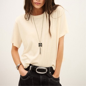 Model wearing Bash cream relaxed T-shirt, styled with a black belt, silver long pendant necklace and silver cuff bracelet.