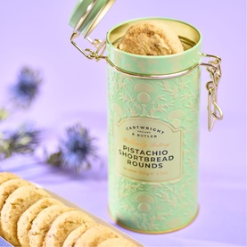 Cartwright & Butler Pistachio Shortbread Rounds in mint green and gold clip-top tin, with biscuits displayed alongside on a lilac background.