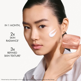 Model with Dior cleanser applied to cheek, holding pink glass jar, with skin radiance and texture claim text overlay