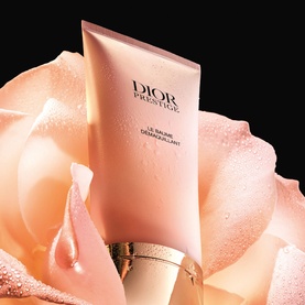Dior Prestige Le Baume D&eacute;maquillant cleansing balm in pale pink tube with gold cap, styled with a soft pink rose bloom