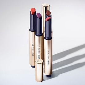 Est&eacute;e Lauder Pure Colour Melt-On Shimmerstick Lip Gloss Stick in three shades including 625 Sparkling Mocktail, gold packaging, open and closed.