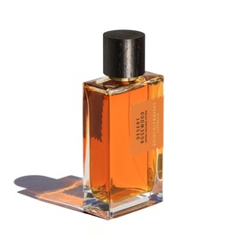Goldfield & Banks EDP in amber glass bottle with black cap, casting warm shadow on white surface